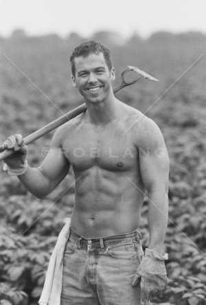 Shirtless-man-holding-a-hoe-in-a-field.jpg